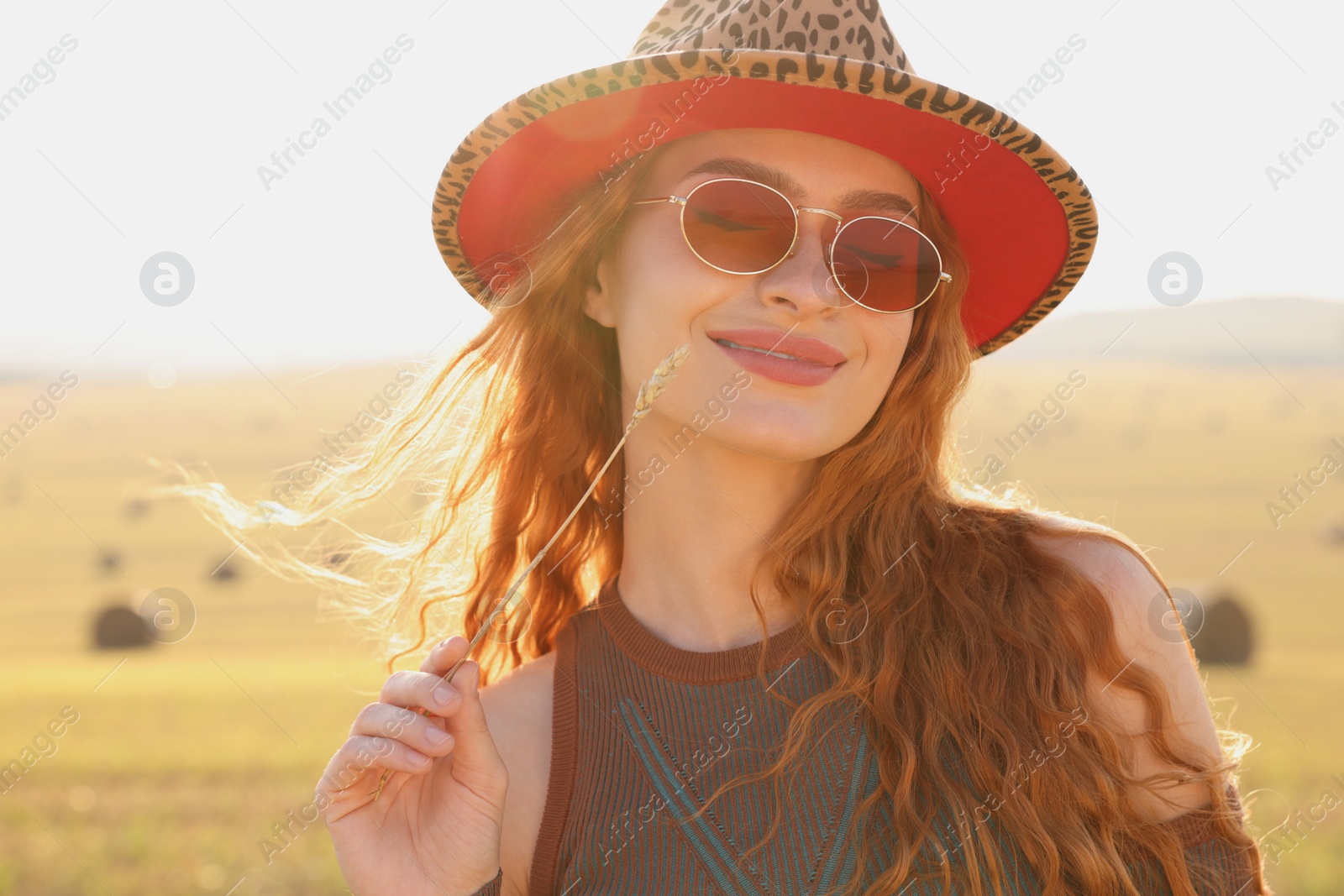 Photo of Beautiful happy hippie woman with spikelet in field