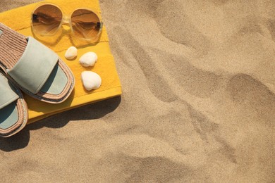 Beach accessories and seashells on sand, top view. Space for text