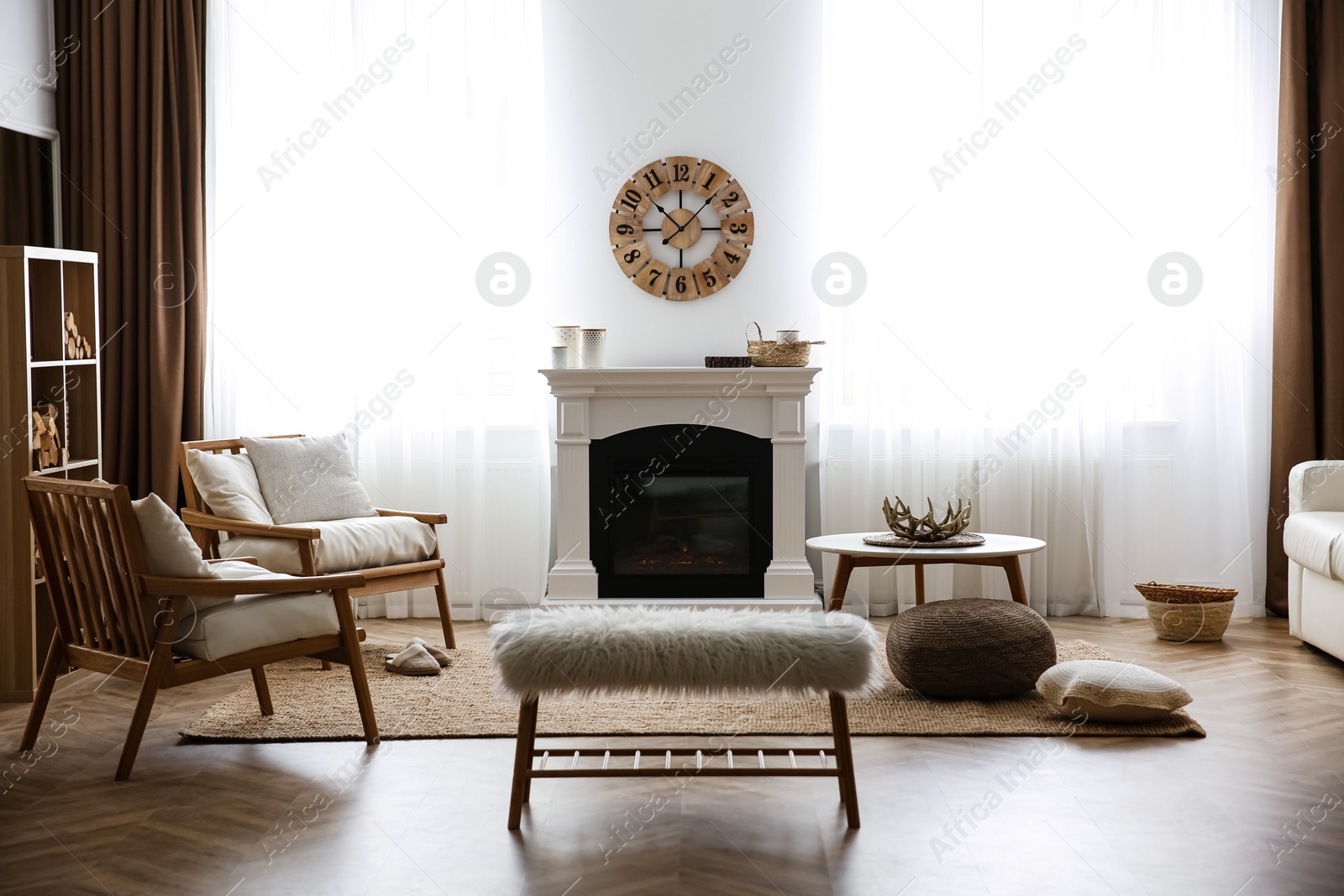 Photo of Elegant artificial fireplace and armchairs in room. Interior design