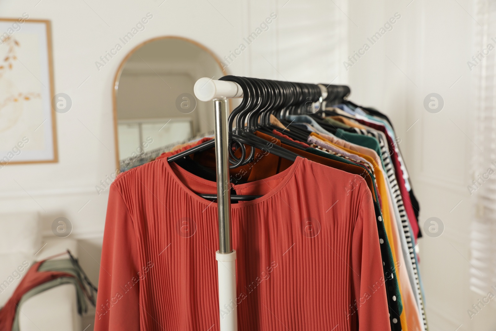 Photo of Rack with stylish clothes indoors. Fast fashion