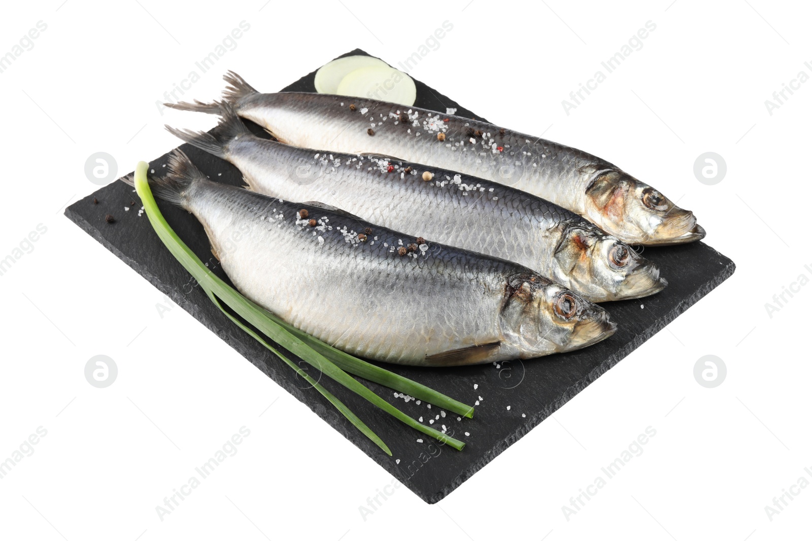 Photo of Slate plate with salted herrings, spices and onion isolated on white