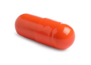 One orange pill on white background. Medicinal treatment