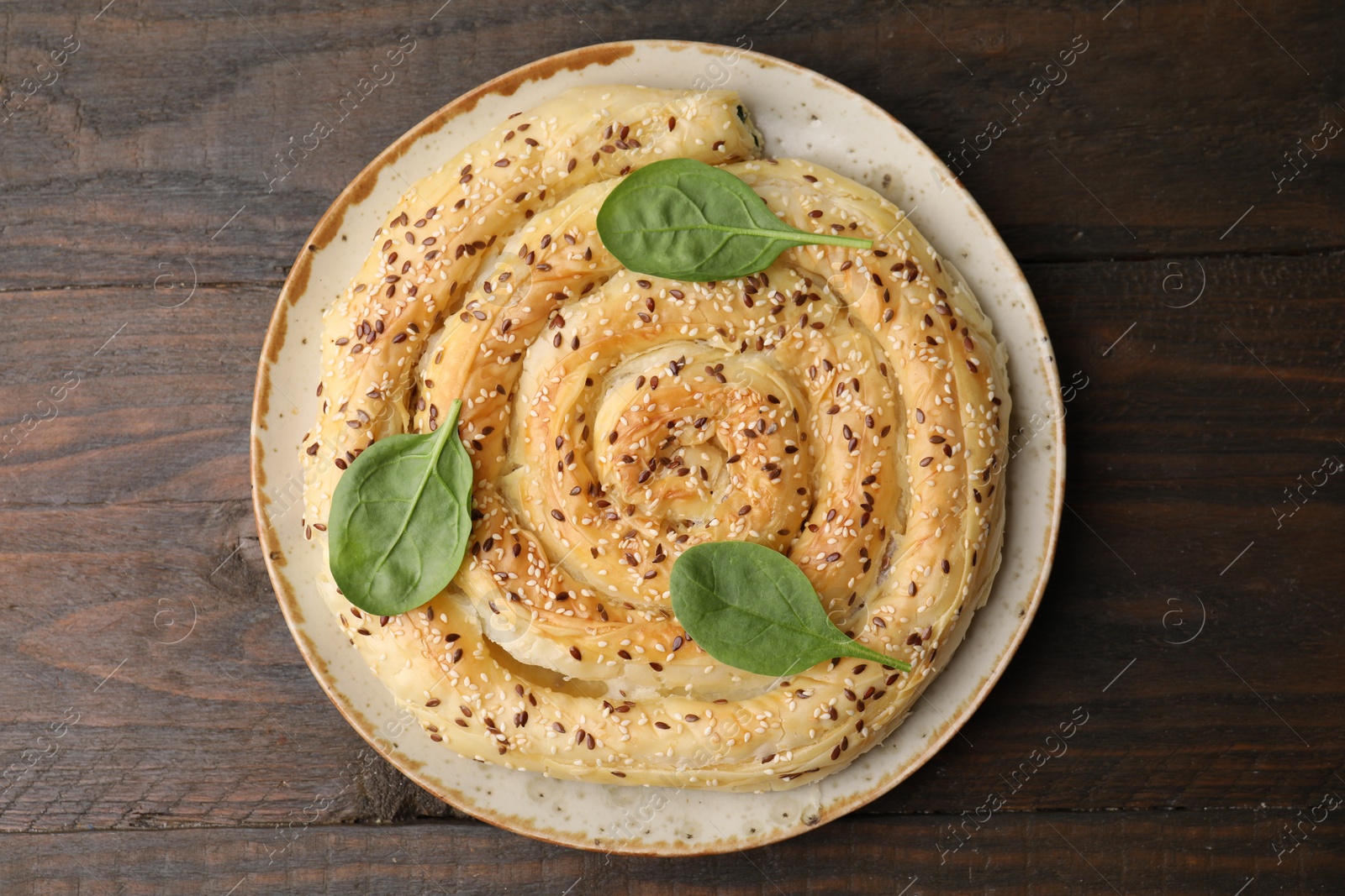 Photo of Delicious puff pastry with spinach on wooden table, top view