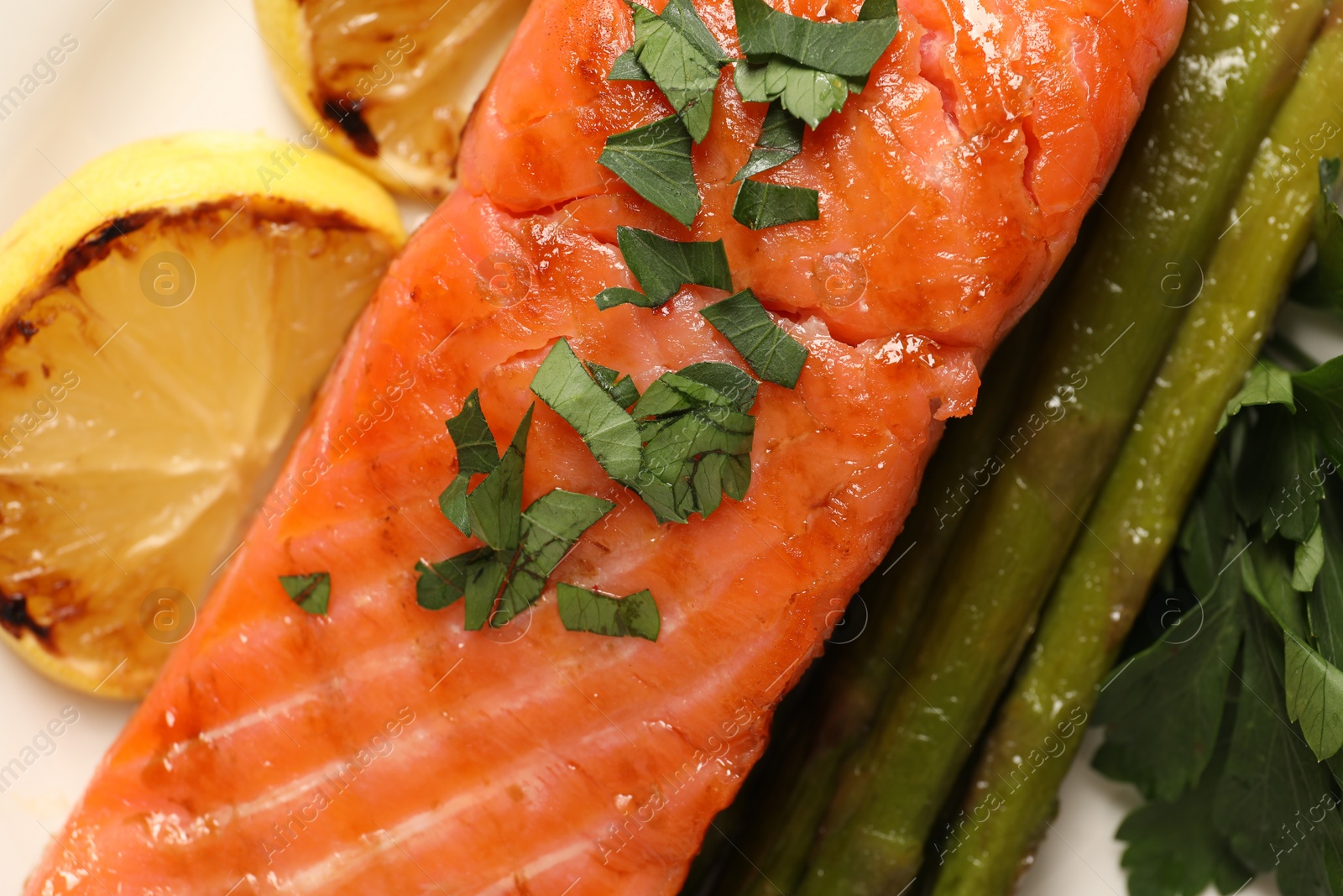 Photo of Tasty grilled salmon with asparagus and lemon, top view