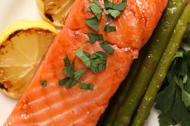 Photo of Tasty grilled salmon with asparagus and lemon, top view