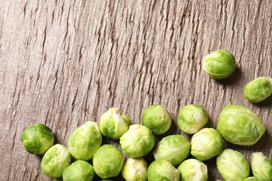 Fresh Brussels sprouts on wooden table, top view. Space for text