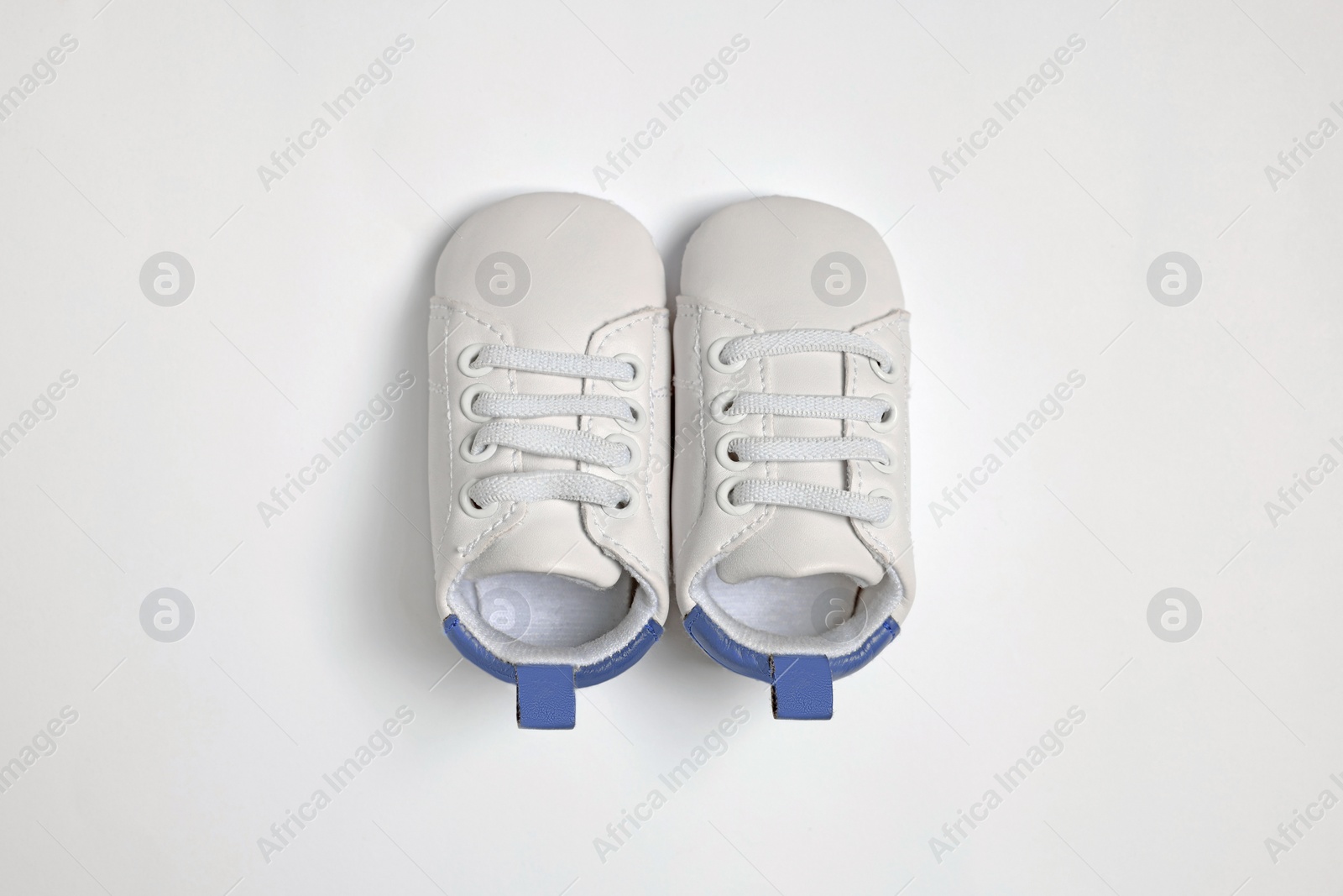 Photo of Cute baby shoes on white background, flat lay