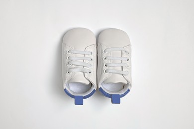 Photo of Cute baby shoes on white background, flat lay