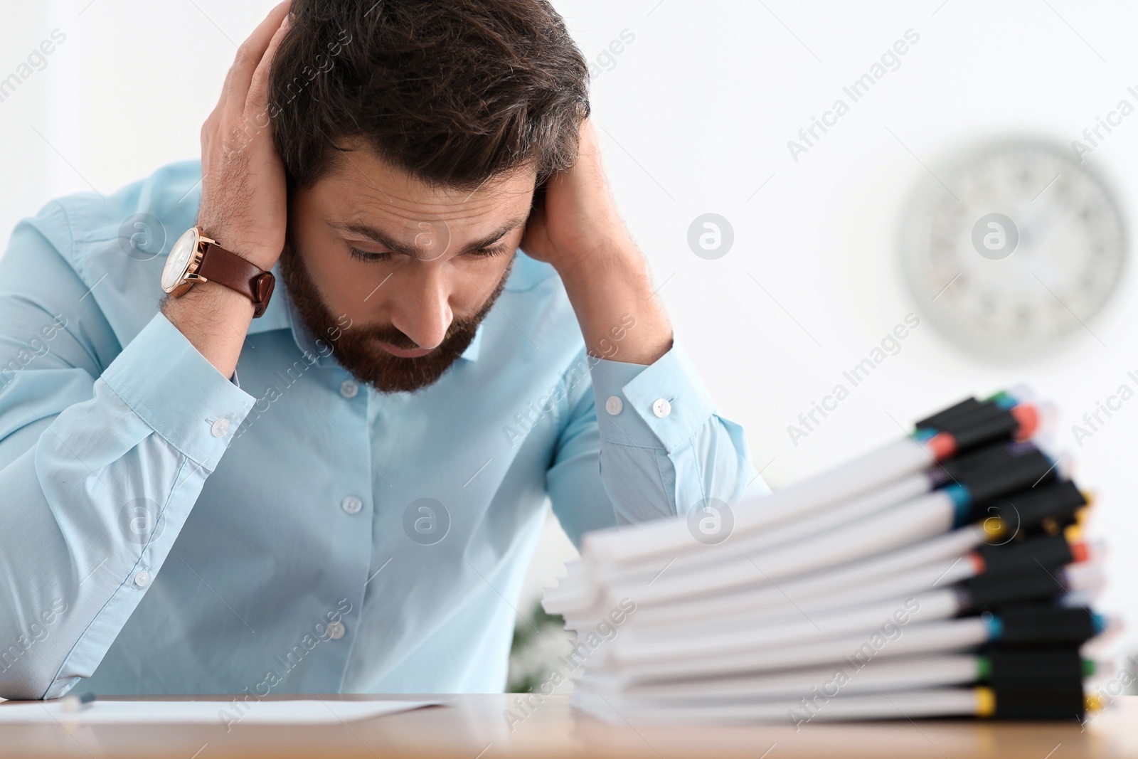 Photo of Emotional businessman with documents at wooden table in office, closeup