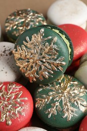 Beautifully decorated Christmas macarons on brown background, closeup