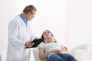 Photo of Orthopedist examining patient with injured neck in clinic