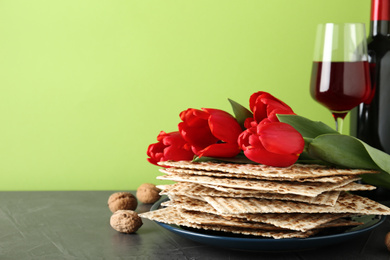 Photo of Composition with Passover matzos on green background, space for text. Pesach celebration