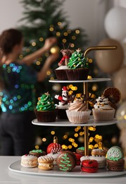 Many different Christmas cupcakes on white table indoors