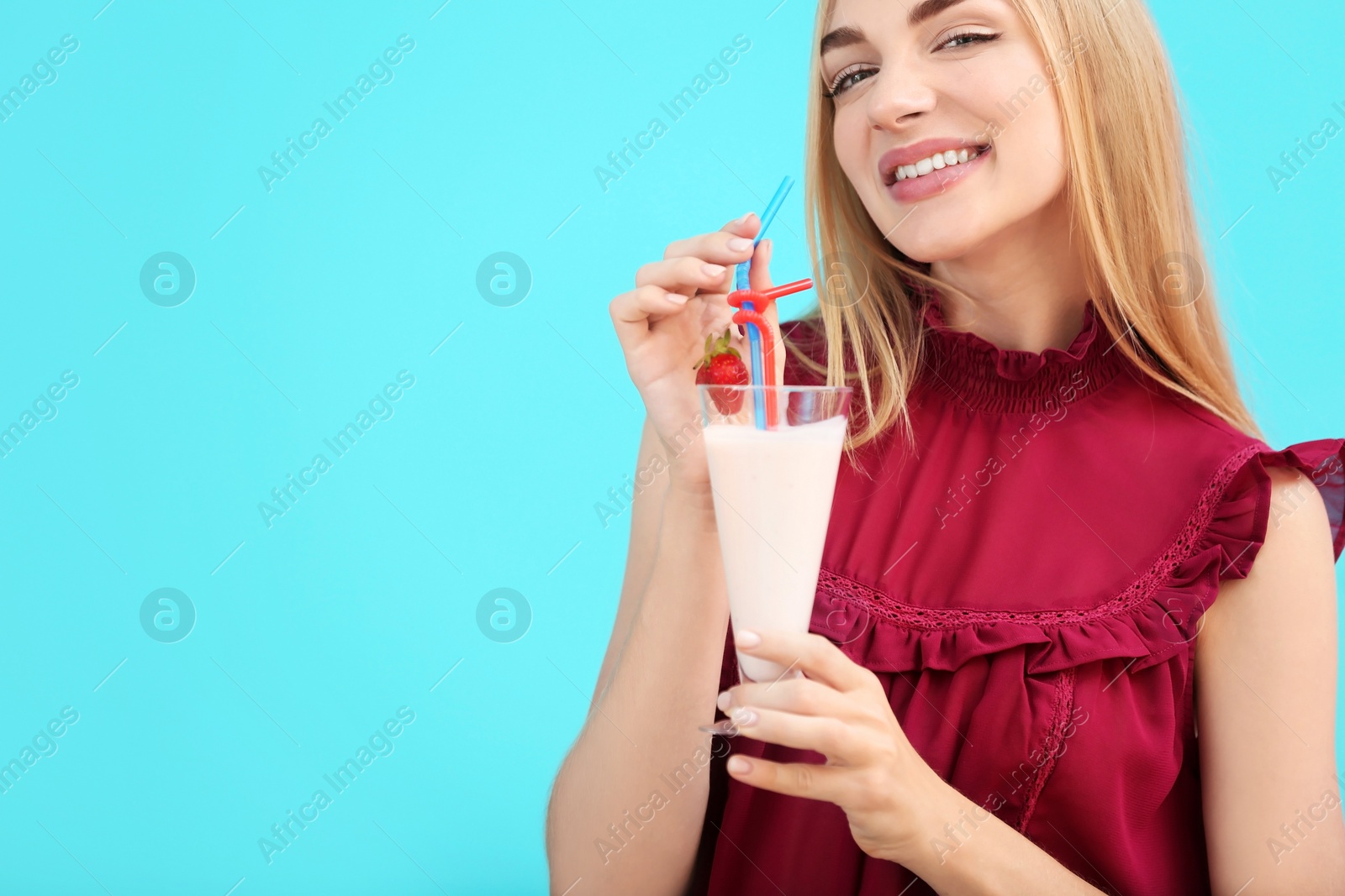 Photo of Young woman with glass of delicious milk shake on color background