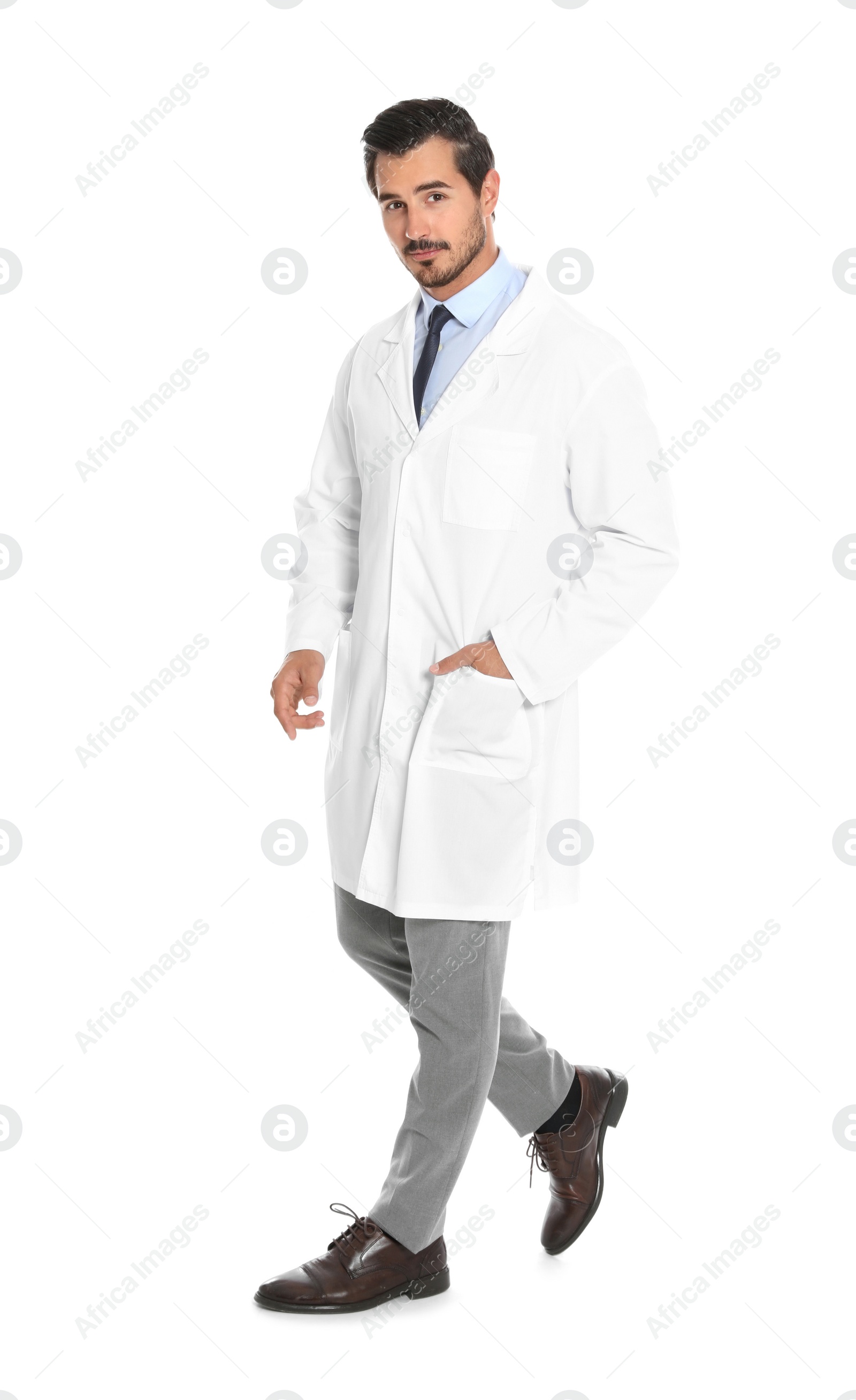 Photo of Young male doctor walking on white background. Medical service