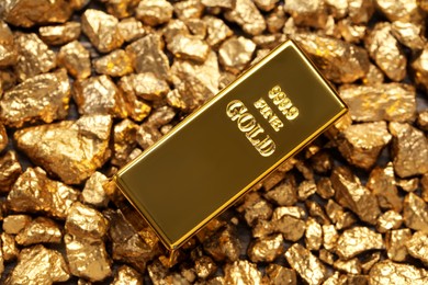 Photo of Shiny gold ingot on nuggets, top view