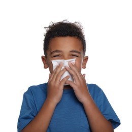 Photo of African-American boy blowing nose in tissue on white background. Cold symptoms