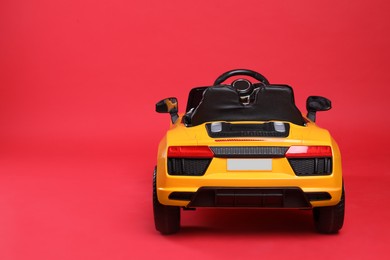 Photo of Child's electric toy car on red background. Space for text