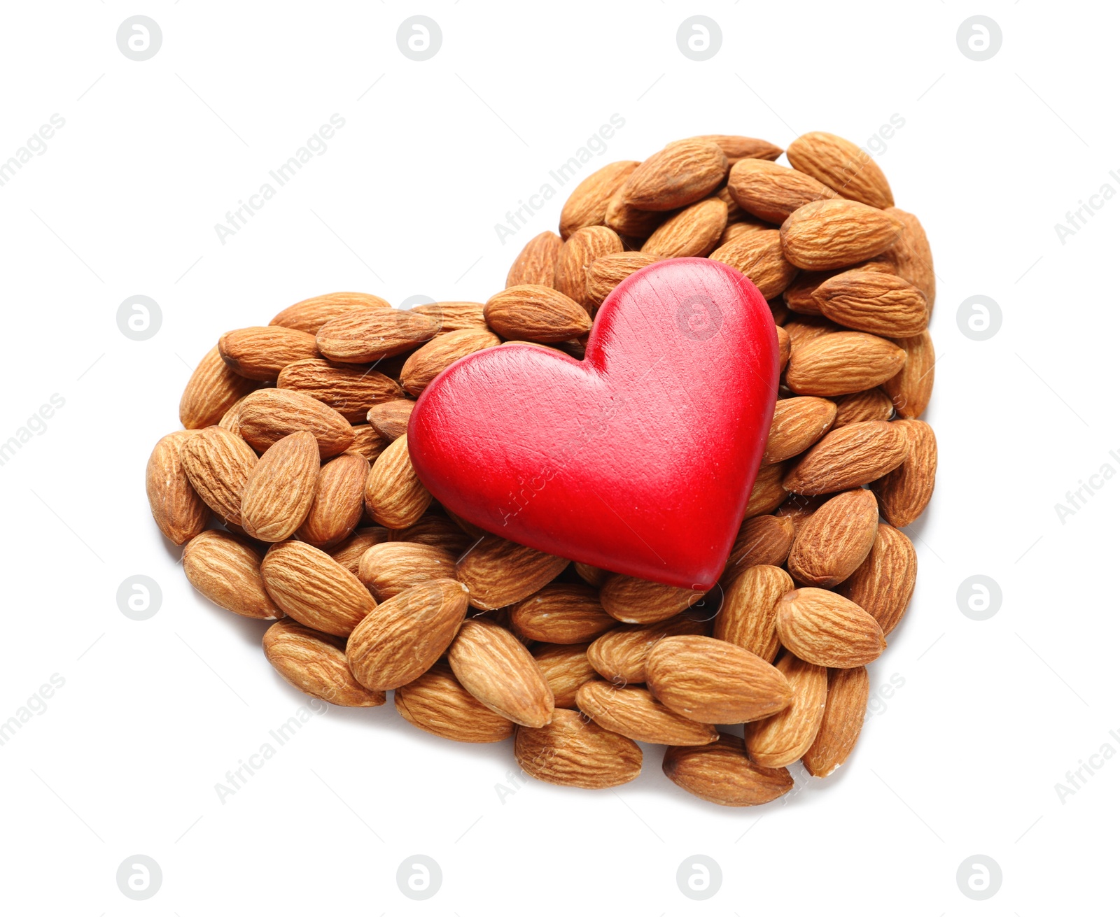 Photo of Heart made of almonds and decor on white background. Healthy diet