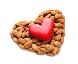 Heart made of almonds and decor on white background. Healthy diet