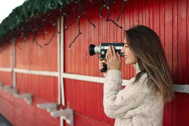 Photo of Beautiful young woman with vintage video camera outdoors