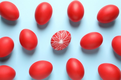 Photo of Flat lay composition of red Easter eggs on color background