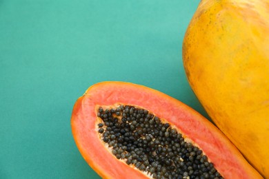 Photo of Fresh ripe cut and whole papaya fruits on light blue background, flat lay. Space for text