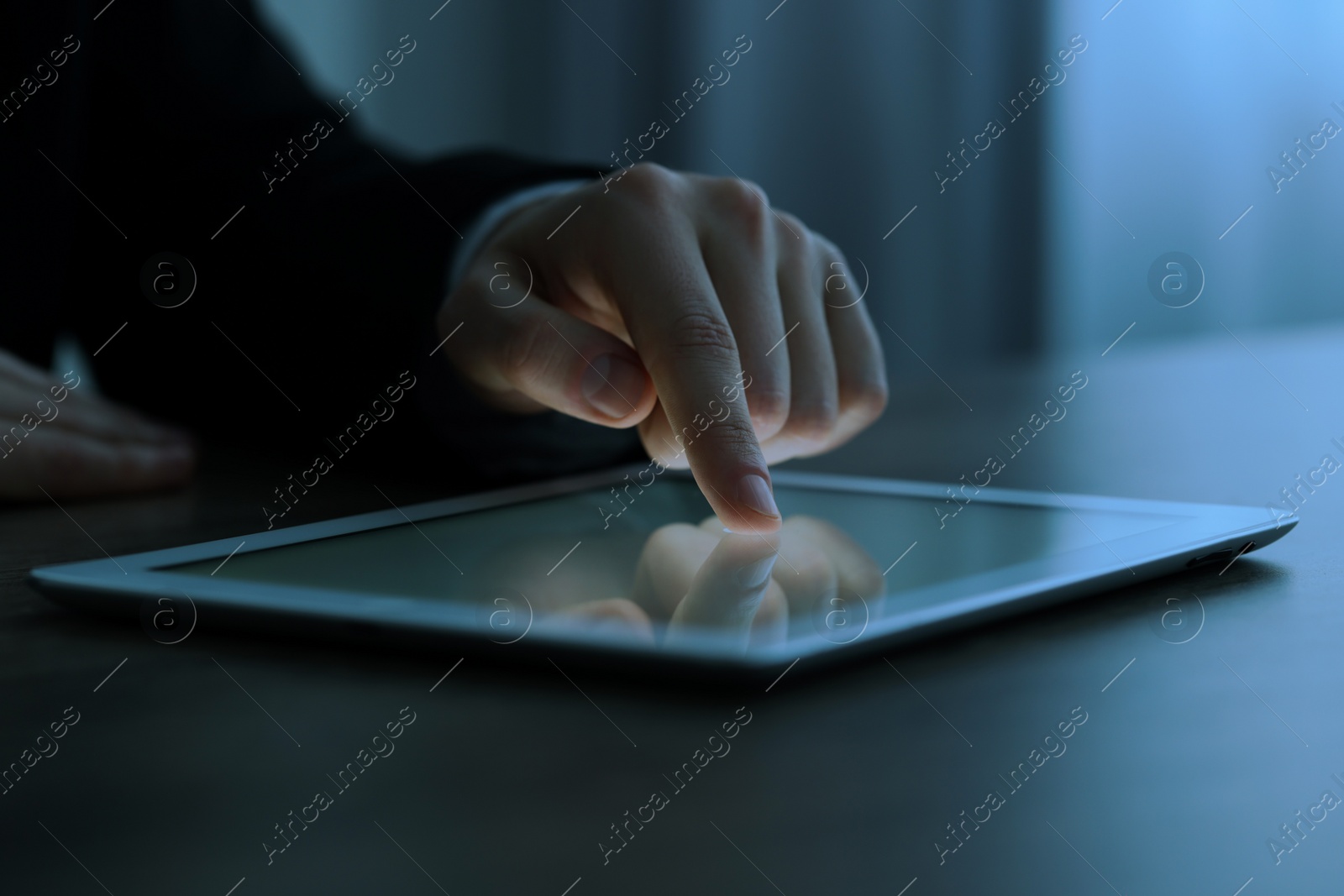 Photo of Man using tablet at wooden table, closeup