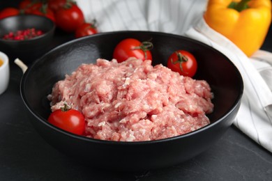 Photo of Raw chicken minced meat with tomatoes on black table, closeup