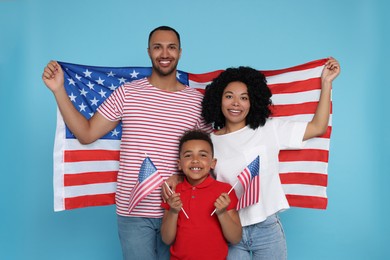 Photo of 4th of July - Independence Day of USA. Happy family with American flags on light blue background