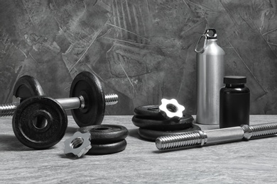 Photo of Composition with dumbbells and fitness accessories on floor