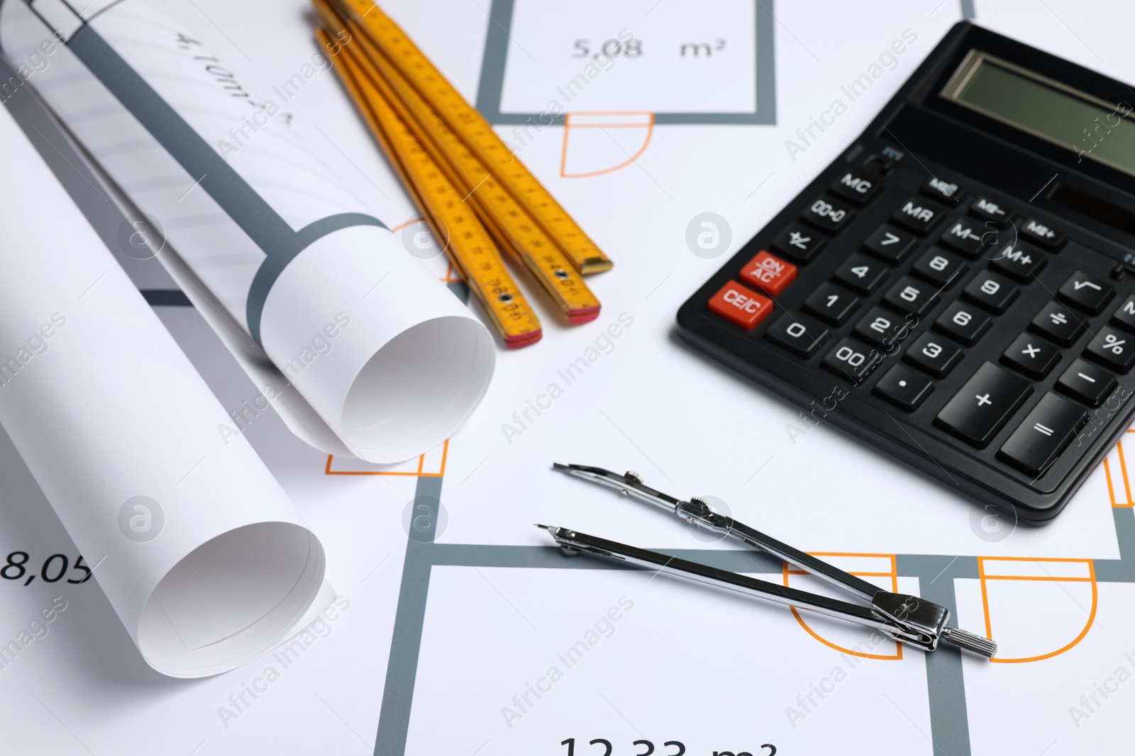 Photo of Construction drawings, calculator, folding ruler and pair of compasses on house plan. Architect workspace