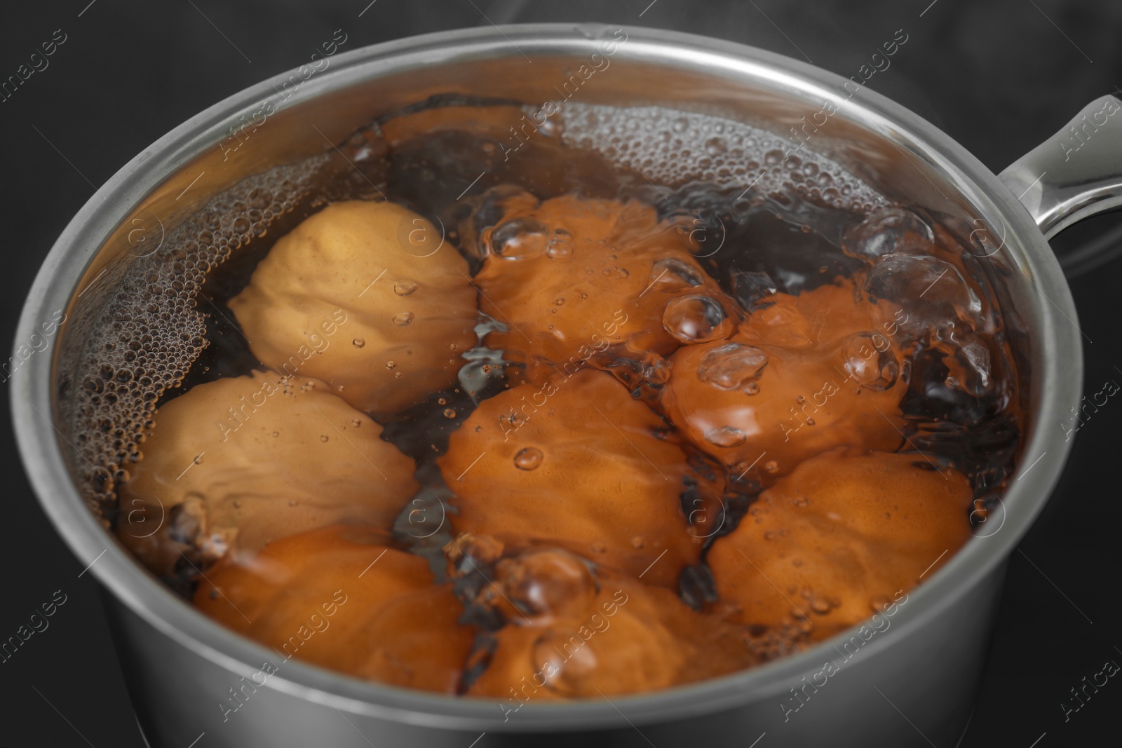 Photo of Boiling chicken eggs in saucepan on electric stove, closeup