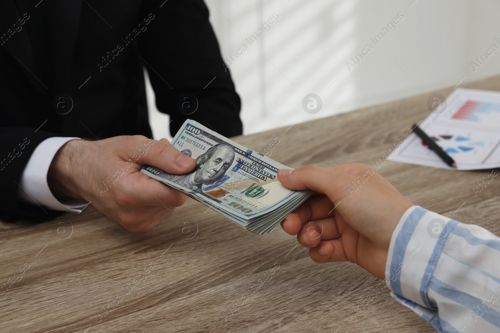 Photo of Cashier giving money to businesswoman at desk in bank, closeup