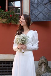 Photo of Happy young bride with beautiful bouquet outdoors. Wedding day