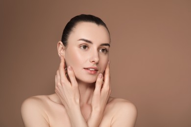 Photo of Portrait of beautiful young woman on brown background. Space for text