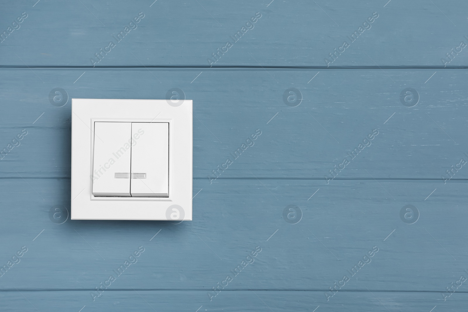 Photo of White light switch on grey wooden background. Space for text