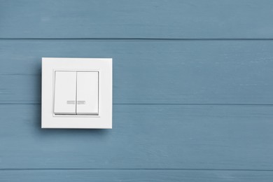 Photo of White light switch on grey wooden background. Space for text