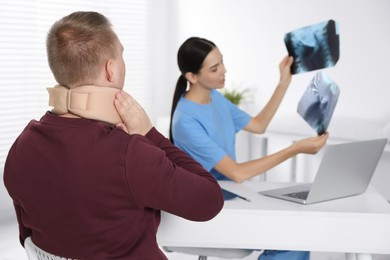 Photo of Doctor with neck MRI images consulting patient in clinic, space for text