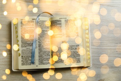 Open Bible on wooden table, top view. Bokeh effect