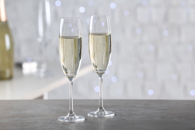 Two glasses of champagne on grey table