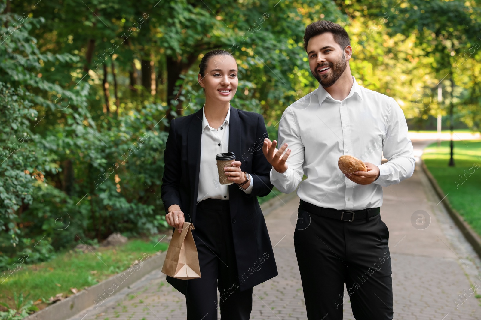 Photo of Business lunch. Happy colleagues spending time together during break in park