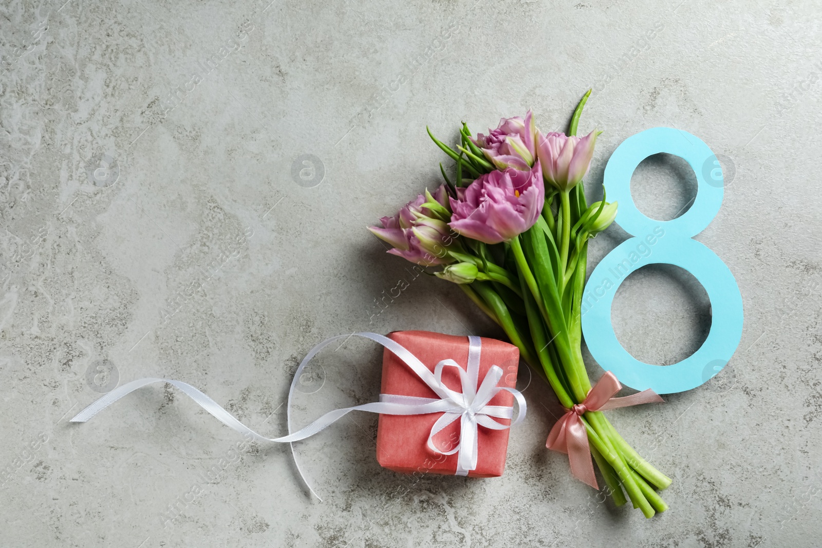 Photo of 8 March greeting card design with tulips and gift on grey background, flat lay. Space for text