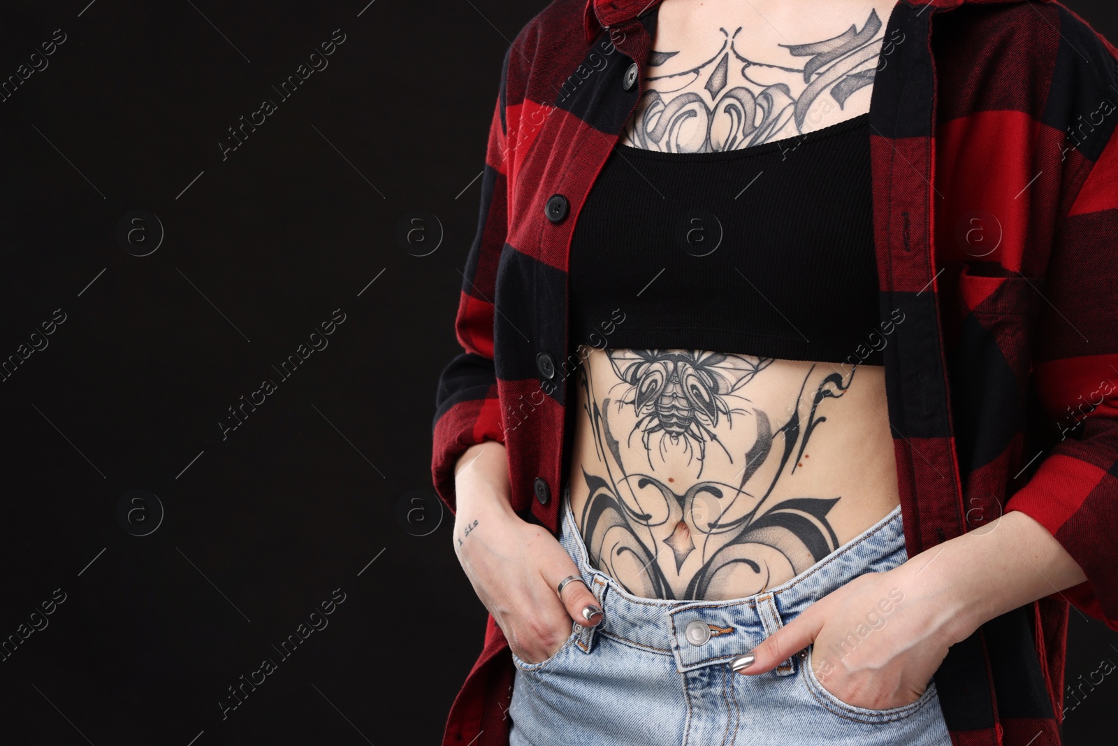 Photo of Woman with cool tattoos on black background, closeup. Space for text