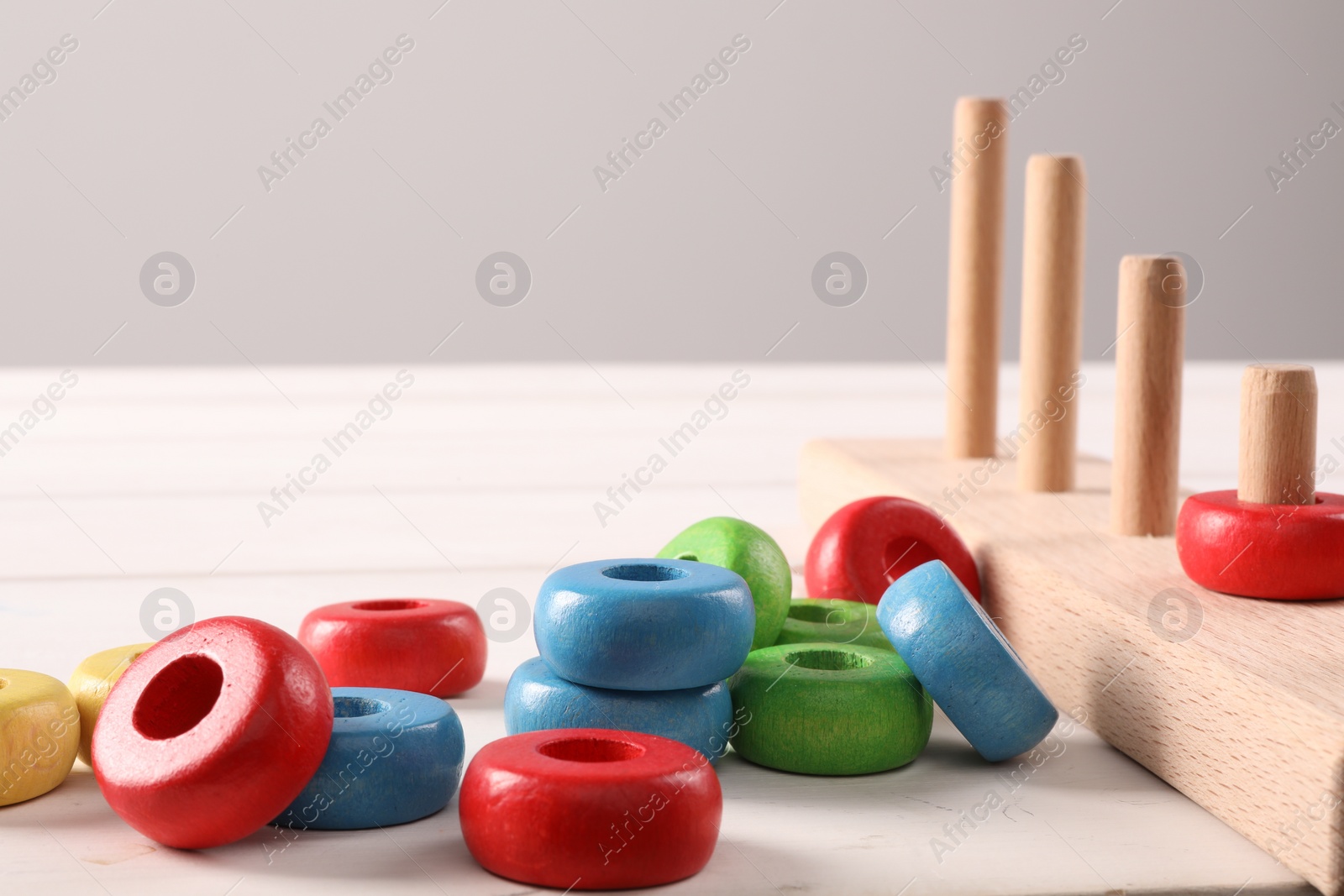 Photo of Motor skills development. Stacking and counting game pieces on white table