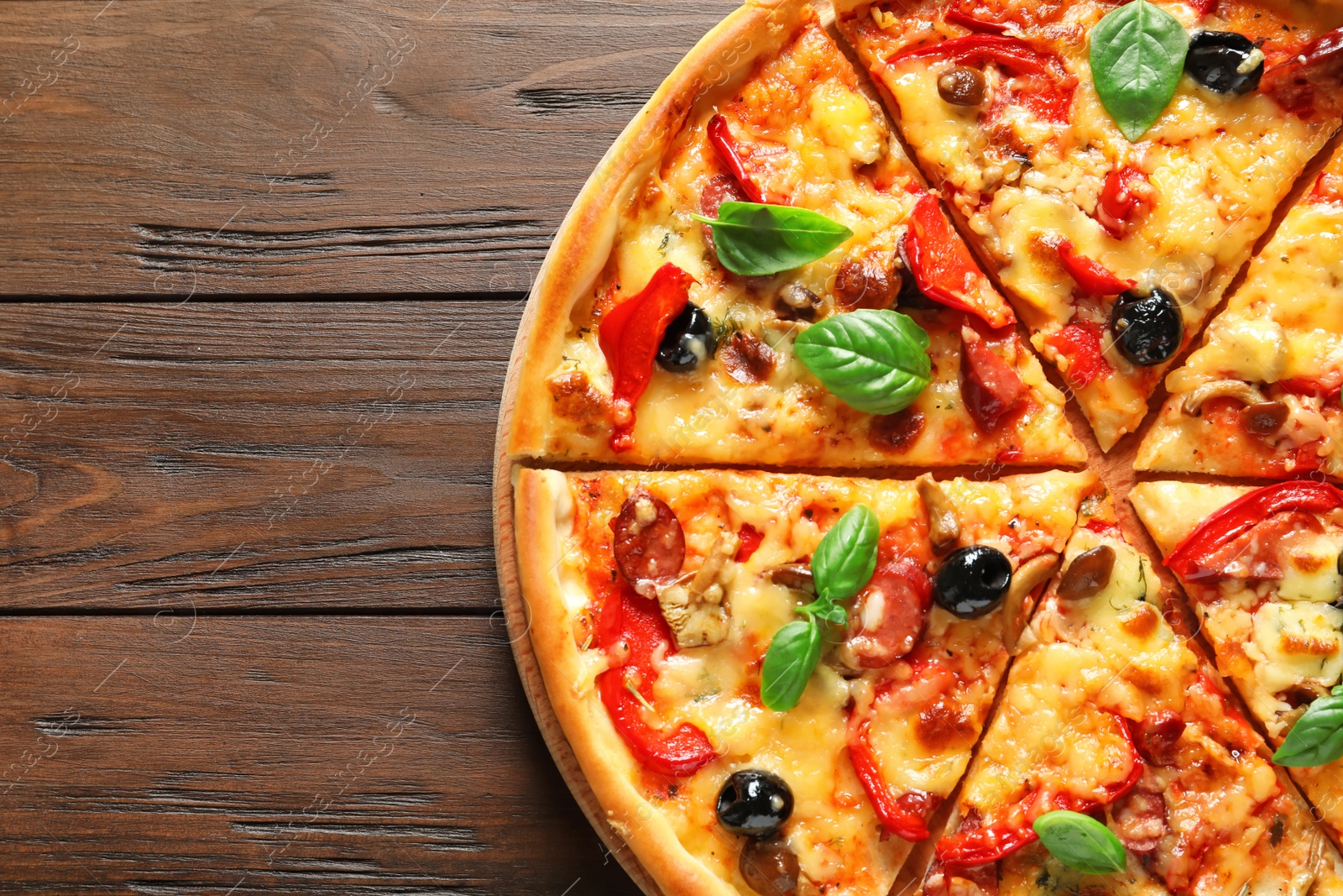 Photo of Delicious pizza with olives and sausages on wooden table, top view