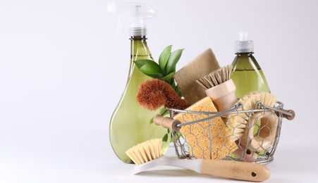 Set of different cleaning supplies in basket on white background