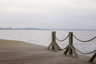 Wooden pier near sea, space for text