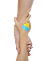 Man and woman with painted heart in colors of Ukrainian flag on her hand against white background, closeup