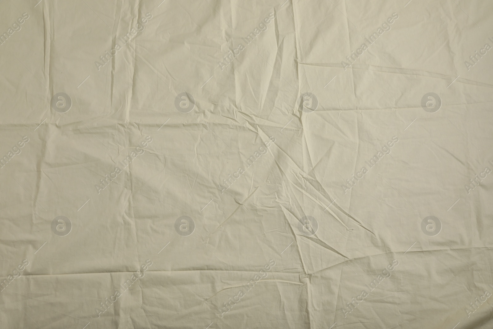 Photo of Crumpled beige fabric as background, top view